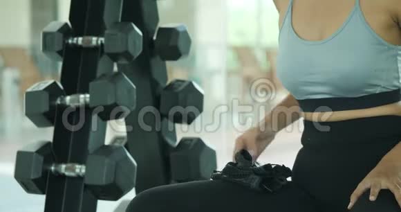 年轻的亚洲女性在健身房锻炼视频的预览图