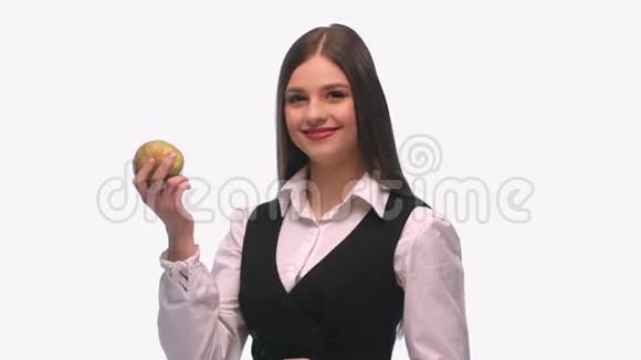 一个穿着西装穿着白色背景的女孩吃着一个有声音的梨视频的预览图