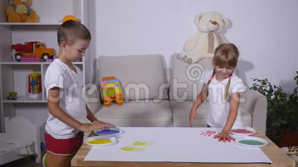 一个女孩和一个男孩在纸上留下了手印视频的预览图