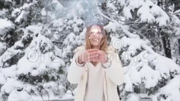 年轻积极的女孩在冬天的森林里下雪圣诞节和火花视频的预览图