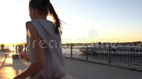 年轻女子在日落时慢跑视频的预览图