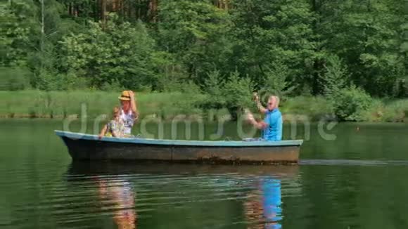 一家人在湖边的小船上放松视频的预览图
