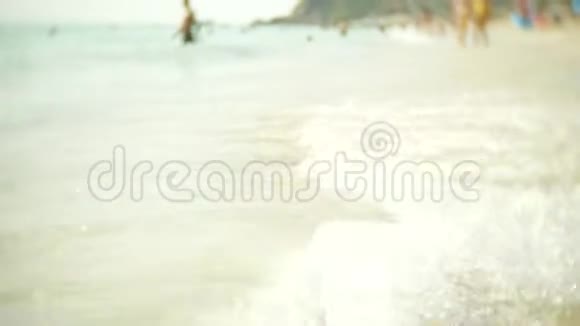 拥挤的沙滩场景与无法辨认的游客侠影4k慢镜头视频的预览图