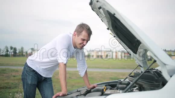 看着汽车发动机的人修理破车的人视频的预览图