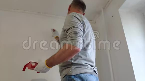 4K胡子男子在平面上用油漆刷粉刷内墙英俊的年轻人在修理积极油漆视频的预览图