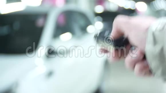 手按遥控器在停车场上的车背景模糊特写复制空间视频的预览图