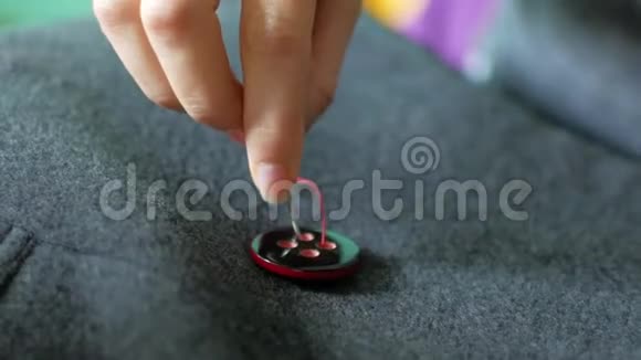 女裁缝在她的衣服上缝一个纽扣针线活和小衣服修理视频的预览图