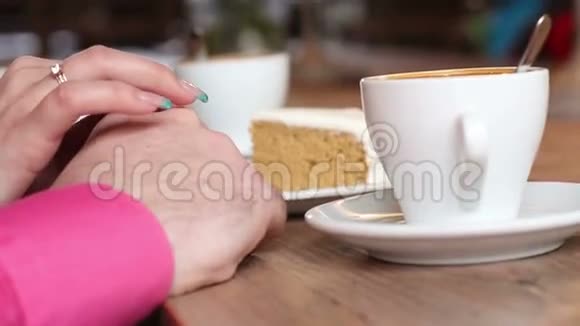 双手靠近咖啡杯和蛋糕视频的预览图