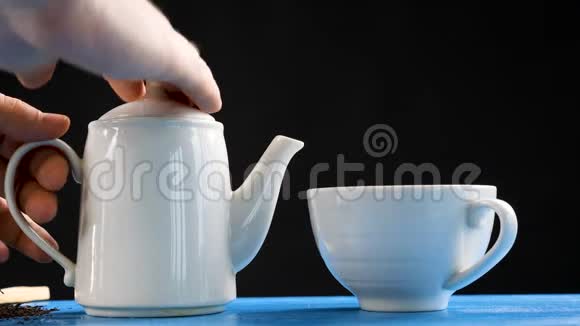 从杯子里的水壶里缓慢地倒茶视频的预览图