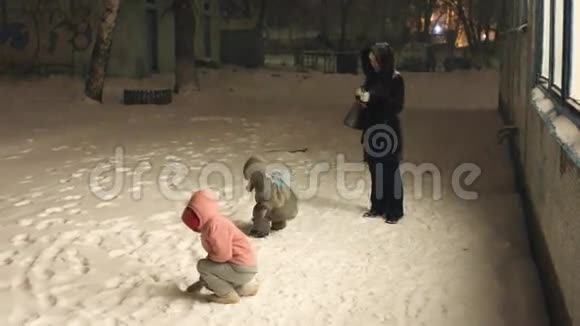 母亲带着两个孩子在雪地里散步视频的预览图