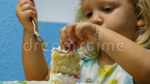 特写小女孩用茶匙吃一块生日蛋糕视频的预览图
