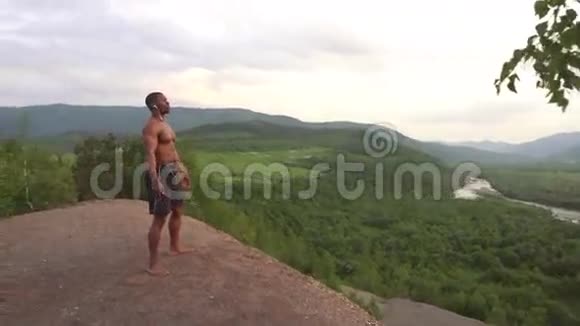 美国黑人健身者的侧面景观在他早晨的户外活动中完美的身体摆在山顶上视频的预览图