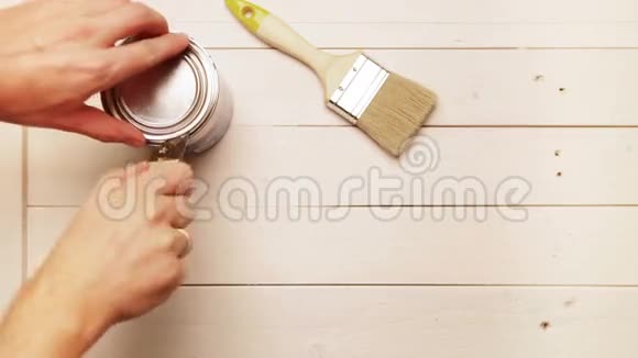 木匠为自己的工作场所做准备用蓝色油漆打开一个锡视频的预览图