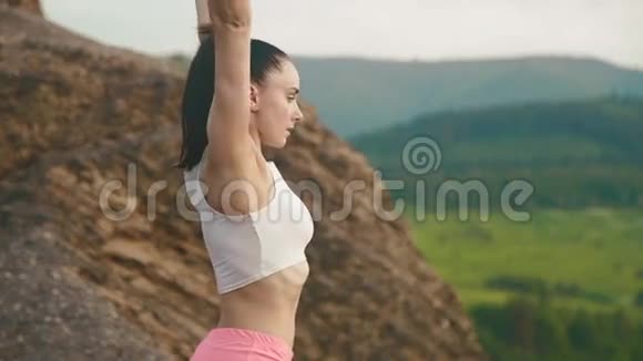 侧面观看健身教练女子在山上做运动适合女性运动员户外运动模式视频的预览图