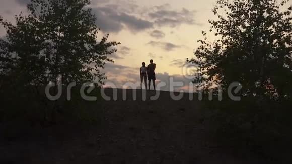 运动型肌肉混合种族夫妇在山上一起看日出的背景图视频的预览图