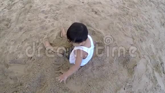 可爱的小男孩在沙滩上玩沙子视频的预览图