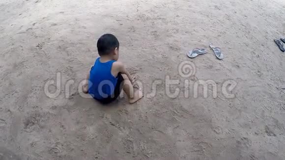 可爱的小男孩在沙滩上玩沙子视频的预览图