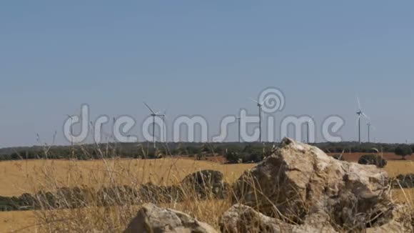 西班牙沙漠中石头背景下的风力涡轮机视频的预览图