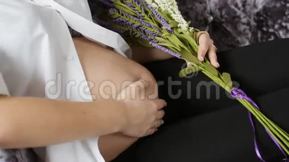 喜孕少女躺在沙发上抚摸你的肚子抱着野花视频的预览图