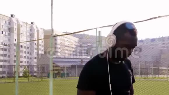 黑人在城市背景下跑步和听音乐帅哥在户外锻炼视频的预览图