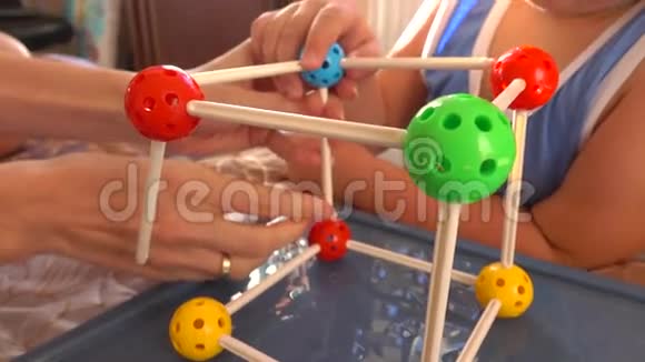 小男孩和他妈妈玩彩色塑料建筑套装分子模型4K关闭视频视频的预览图