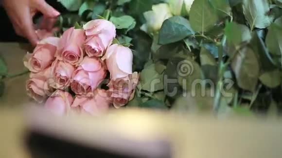 女人的手在店面拿着粉红色的玫瑰视频的预览图
