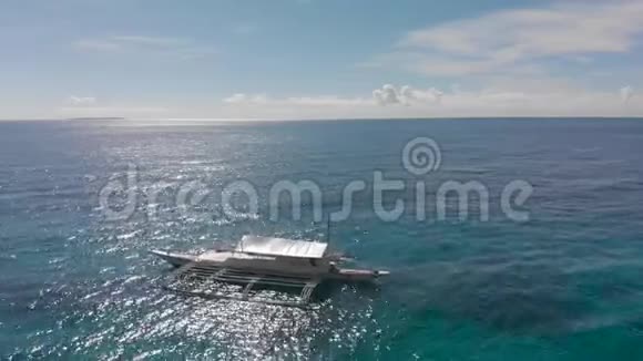 白色旅游船在蓝色平静的海洋附近的沙滩空中电影无人机射击视频的预览图