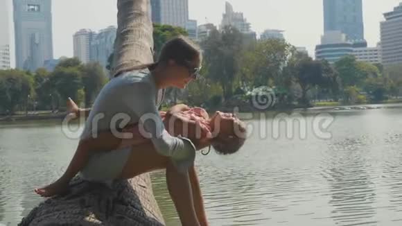 一家人在公园里玩湖和背景上的摩天大楼视频的预览图