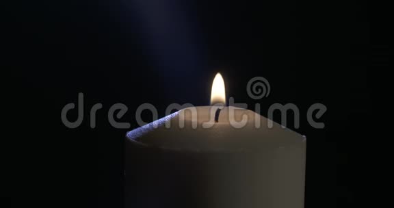 一支蜡烛在黑暗的背景上旋转视频的预览图