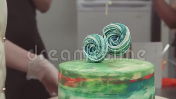 糕点厨师用棒棒糖装饰彩色海绵蛋糕视频的预览图