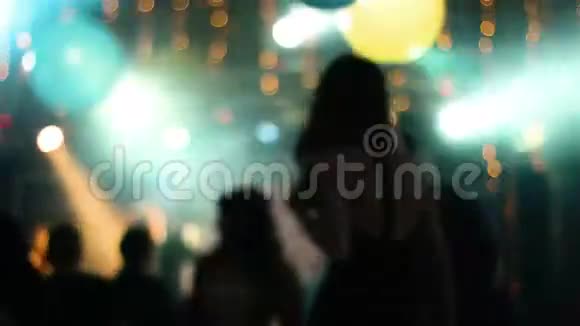 模糊的镜头与年轻迷人的人在夜总会跳舞女孩回到镜头前跳舞视频的预览图