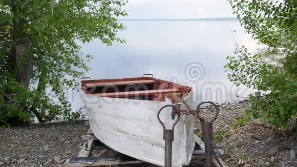 旧的划船渔船被绑起来用链子拴在河岸上视频的预览图