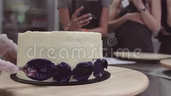 糖果手涂抹白色糖霜上的紫色折痕视频的预览图