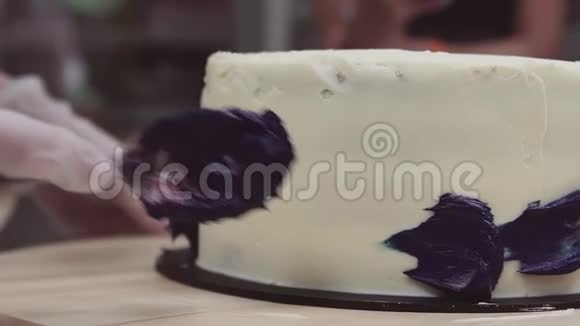 糕点厨师手工涂抹紫色奶油白色糖霜视频的预览图