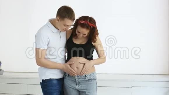 年轻的父母把心脏放在孕妇的肚子上慢动作视频的预览图