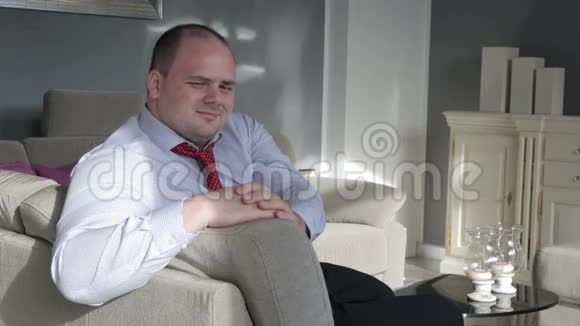 商人坐在客厅的沙发上在镜头前调情视频的预览图