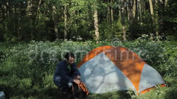 那个人在帐篷附近戴着一个背包清晨在森林里视频的预览图
