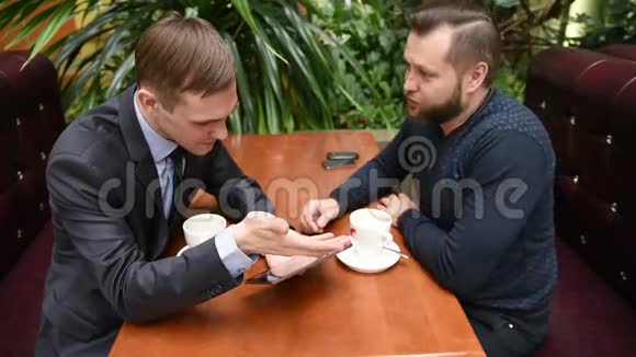 两个人在咖啡馆用平板电脑心烦意乱视频的预览图