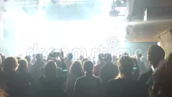 摇滚音乐会上的人群人物剪影灯光和激光舞台上的艺术家视频的预览图