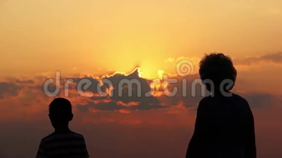 在夕阳下太阳在黎明时牵着母亲的手剪影视频的预览图