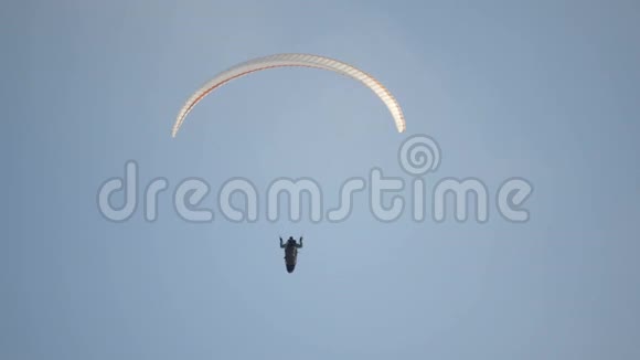 滑翔伞的飞行员在空中盘旋飞行员滑翔伞对抗蓝天视频的预览图