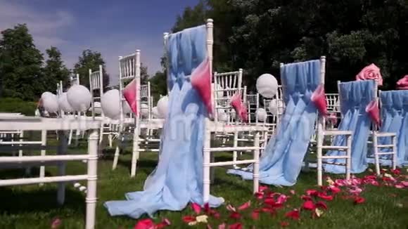 红玫瑰花瓣为婚礼在开放的乡村夏天温暖的天气夏瓦里椅子视频的预览图