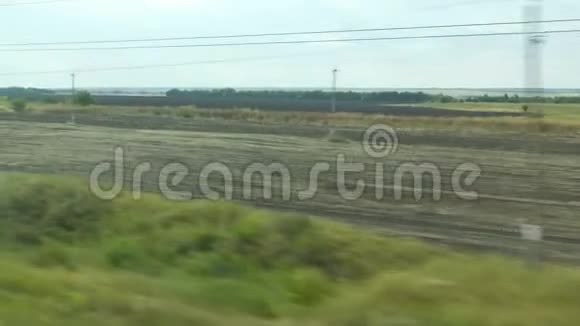 从移动列车的窗口拍摄俄罗斯秋季景观田野森林种植天空视频的预览图