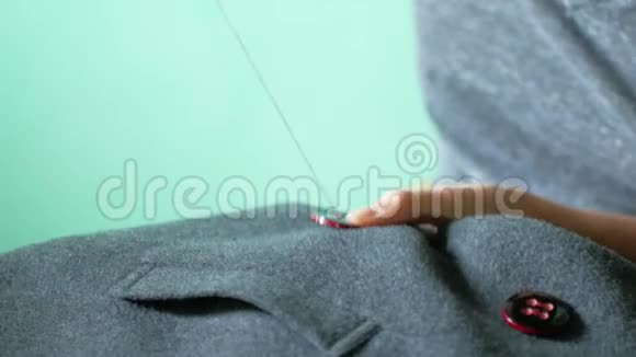 女裁缝在她的衣服上缝一个纽扣针线活和小衣服修理视频的预览图