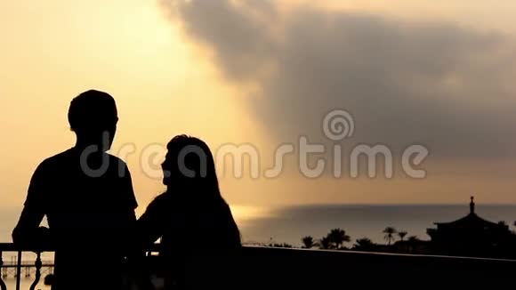 日落时分一对相爱的夫妇在海边跳舞和拥抱的剪影视频的预览图