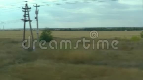 从移动列车的窗口拍摄俄罗斯秋季景观田野森林种植天空视频的预览图