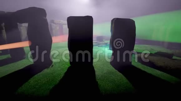 在雾中飞行和环绕巨石阵飞行有着五颜六色的聚光灯视频的预览图