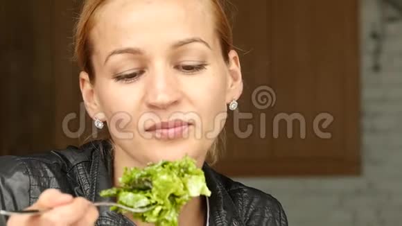 女商人在户外咖啡馆吃沙拉健康的生活方式女孩吃绿色美味的食物慢动作视频的预览图