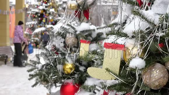 圣诞树上覆盖着雪上面装饰着玩具在街上有一场暴风雪在后台出去视频的预览图