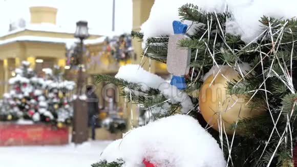 圣诞树上覆盖着雪上面装饰着玩具在街上有一场暴风雪在后台出去视频的预览图